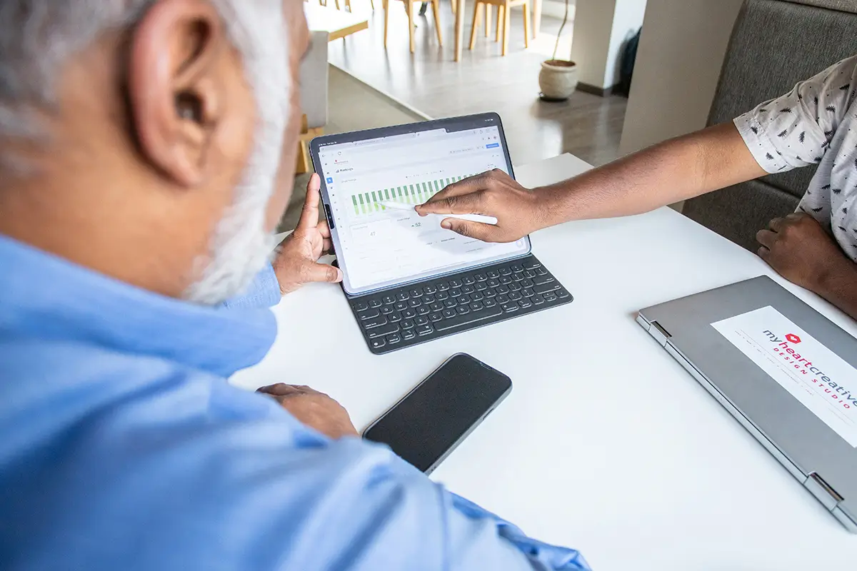 Two SEO experts analyze metrics on a tablet