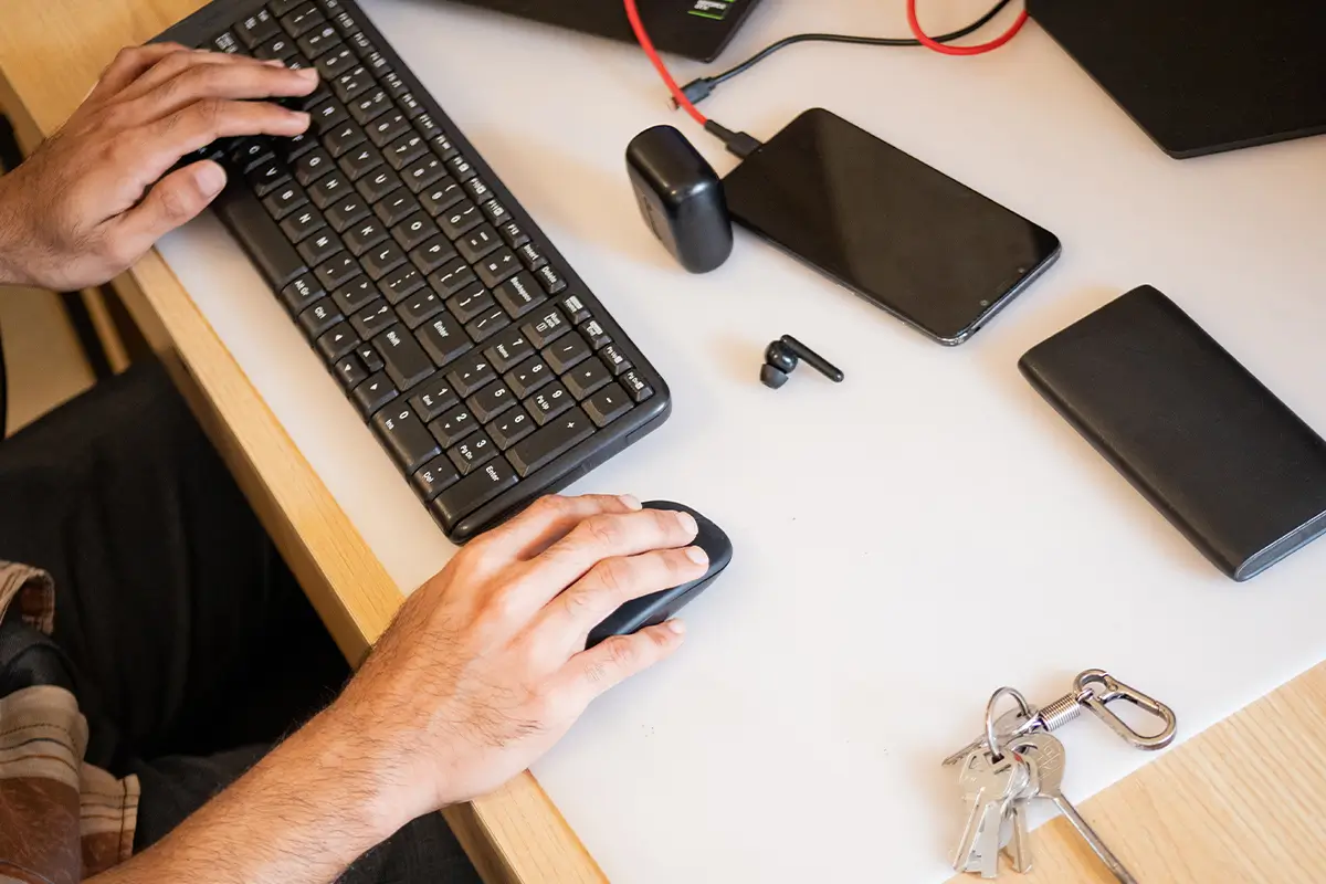 Hands typing on keyboard and mouse