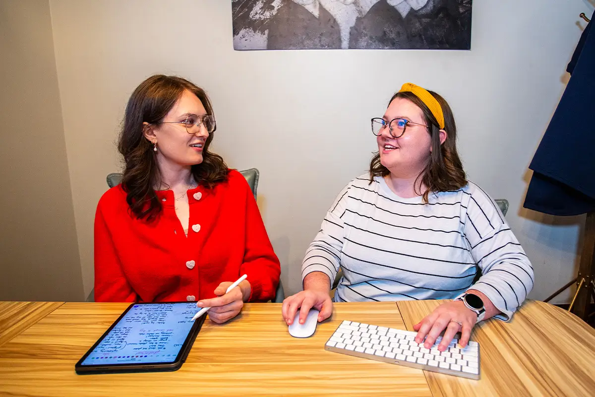 Kristen and Caitlin talking in the conference room.